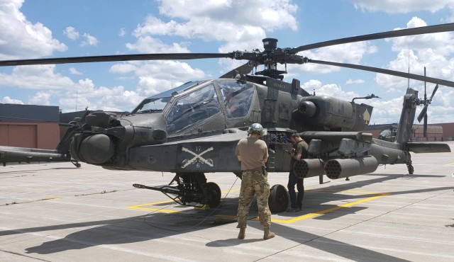 Electronics Mechanic Leader Jason Kilmer repairs the transponder on an AH-64D Apache Attack Helicopter at Fort Drum, New York. (Photo by Michael Carson)