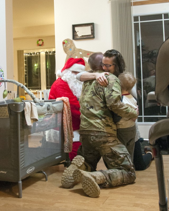 Capt. Jeff Grace, hugs his wife, Sara, and son, Remington, after surprising them by returning home early from his overseas deployment with the help of Santa Claus and the Fort Wainwright Fire Department on Dec. 18. Grace deployed earlier this year with the 1st Stryker Brigade Combat Team, 25th Infantry Division, in support of Operation Inherent Resolve. (Photo by Daniel Nelson, U.S. Army Garrison Alaska, Fort Wainwright Public Affairs)