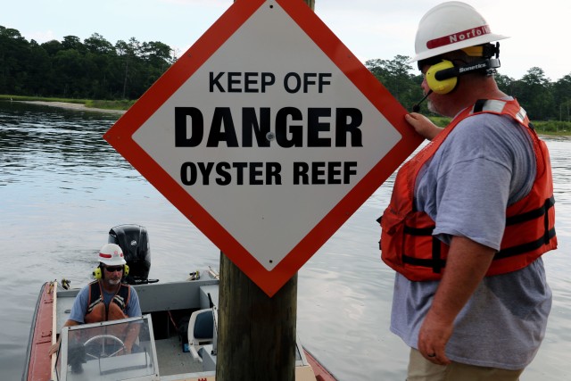 Rick Bruton, left, and Erik Sherer of the Norfolk District, U.S. Army Corps of Engineers Navigation Support Section, place signange for boaters near Broad Bay in the Lynnhaven River, Virginia, July 29, 2020. The signs will serve to inform those on...