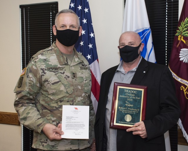 Maj. Gen. Dennis P. LeMaster, Commanding General U.S Army Medical Center of Excellence, presents Mr. Robert (Bob) Preshong, Department of Combat Medic Training, with the U.S. Army Training and Doctrine Command (TRADOC) Civilian Instructor of the Year award along with a letter from Gen. Paul E. Funk II, Commanding General TRADOC.