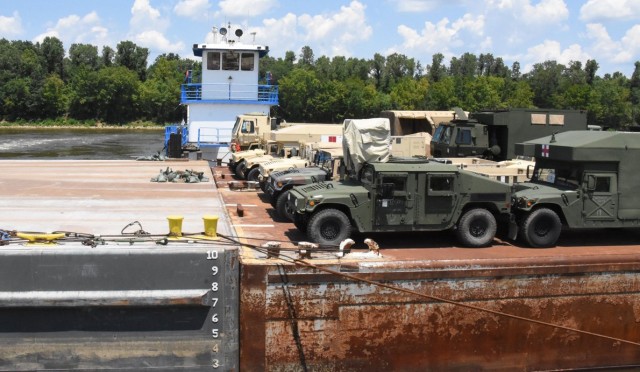 Vehicles belonging to the 2nd Brigade Combat Team, 101st Airborne Division, from Fort Campbell, Ky., prepare to off-load from a barge at the Central Louisiana Regional Port in Alexandria, La., Aug. 3.