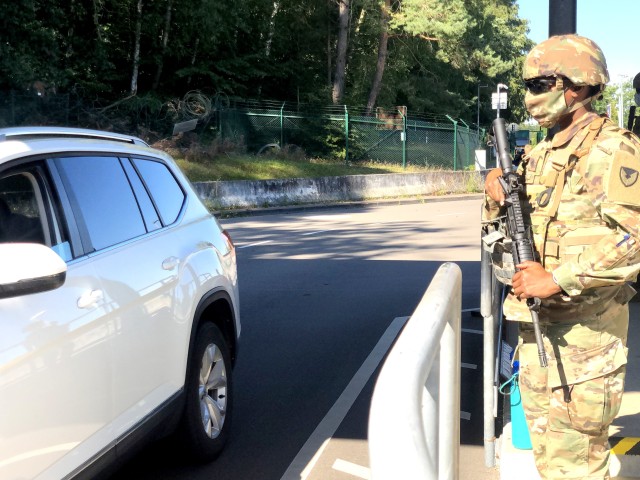 Sgt. Francesca Cyma, Headquarters and Headquarters Company, USAG Rheinland-Pfalz, stands guard, backing up the contractor gate guards, at a Pulaski Barracks gate in Kaiserslautern, Germany as part of a Troop Diversion exercise during...