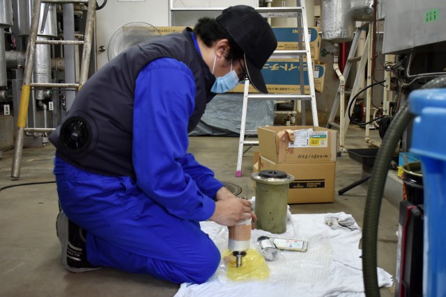 A contractor begins repairing an air conditioner in Building 1050 at Camp Zama, Japan, Aug. 6.