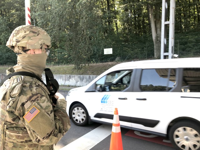 Pfc. Samuil Matveen, Headquarters and Headquarters Company, USAG Rheinland-Pfalz, stands guard, backing up the contract gate guards, at a Pulaski Barracks gate in Kaiserslautern, Germany as part of a Troop Diversion exercise during...