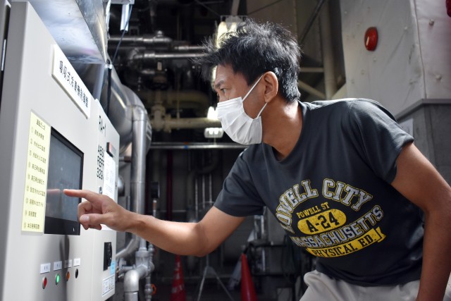 Makoto Akabame, a mechanical system inspector for the Directorate of Public Works, U.S. Army Garrison Japan, reads a monitor during an air conditioning repair in Building 1050 at Camp Zama, Japan, Aug. 6.