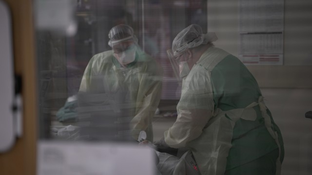 Nurses tend to a patient on extracorporeal membrane oxygenation, or ECMO, in a COVID-19 intensive care unit at Brooke Army Medical Center, Joint Base San Antonio-Fort Sam Houston, Texas, July 17, 2020. (U.S. Army photo by James Camillocci)