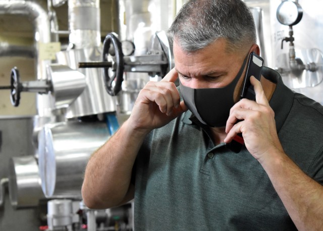 Ben Ingram, supervisory engineering technician, Housing Division, Directorate of Public Works, U.S. Army Garrison Japan, receives a cell phone call about an air conditioning repair in Building 1050 at Camp Zama, Japan, Aug. 6.