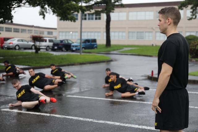 Staff Sgt. Jeffrey Snell, assistant instructor for the Basic Leader Course, watches over a rainy physical fitness session July 17 on Camp Zama, Japan. Twenty Soldiers completed a distance-learning version of BLC at their installation because the course, normally held in Korea, is currently not being held there due to concerns over COVID-19. (U.S. Army photo by Noriko Kudo)