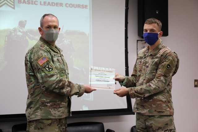 Spc. Victor Zalek, assigned to the 623rd Movement Control Team, receives a certificate of achievement July 31 from assistant instructor Master Sgt. Jason Garrison, upon completing a distance-learning version of the Basic Leader Course held on Camp Zama, Japan. (U.S. Army photo by Noriko Kudo)