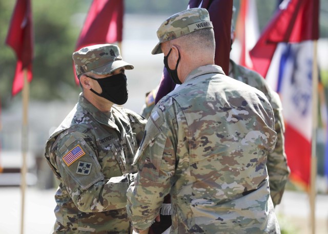 Col. Michael Weber (right), commander, Landstuhl Regional Medical Center, passes the unit colors to Command Sgt. Maj. John Contreras during a Relinquishment of Responsibility Ceremony, at LRMC, Aug. 5.