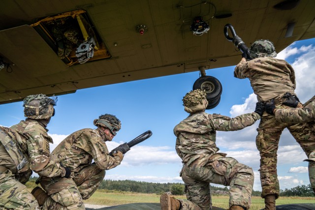 A CH-47 Chinook from B Co "Big Windy," 1-214th General Support Aviation Battalion hovers low while paratroopers from the 173rd Airborne Brigade  hook their pallet of equipment to the underside of the helicopter. (U.S. Army photo by Maj. Robert Fellingham)