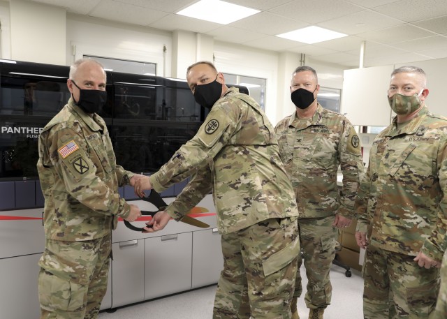 Brig. Gen. Mark Thompson (right), commanding general, Regional Health Command Europe, and Command Sgt. Maj. Kyle Brunell, command sergeant major, RHCE, cut a ribbon to introduce Landstuhl Regional Medical Center’s first high-throughput testing system for COVID-19, July 8.