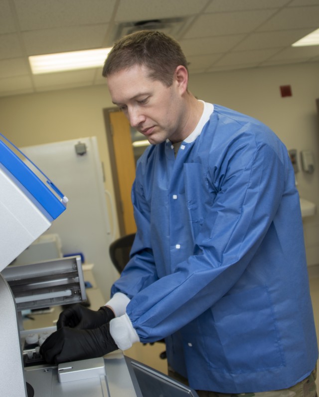 Army Capt. Eric Coate, Molecular Diagnostics officer in charge, loads patient samples for COVID-19 ribonucleic acid (RNA) testing at Brooke Army Medical Center, Fort Sam Houston, Texas, April 9, 2020. (U.S. Army photo by Jason W. Edwards)