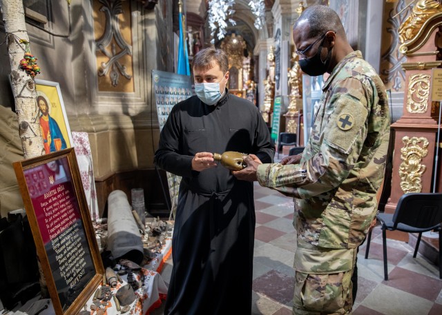 Task Force Illini Chaplain, (Maj) Vincent Lambert, examines a canteen with several bullet holes during a tour of Garrison Church in Lviv, Ukraine, Aug. 5 during his introductory meeting with Armed Forces Ukraine senior chaplain, Father Mykhalchuk Taras. (Photos by Army Cpl. Shaylin Quaid, JMTG-U Public Affairs)