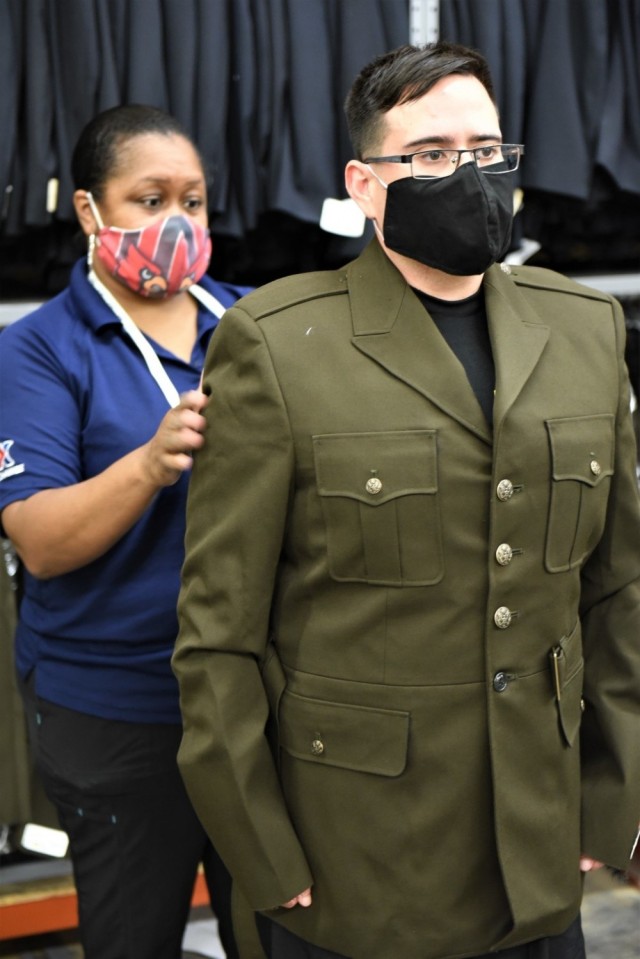 An AAFES employee at Fort Knox, Ky., checks the fit of a recruiting student&#39;s Army Green Service Uniform coat July 8, 2020. Recruiting students attending the Army Recruiting Course were among the first to receive the World War II style uniforms.