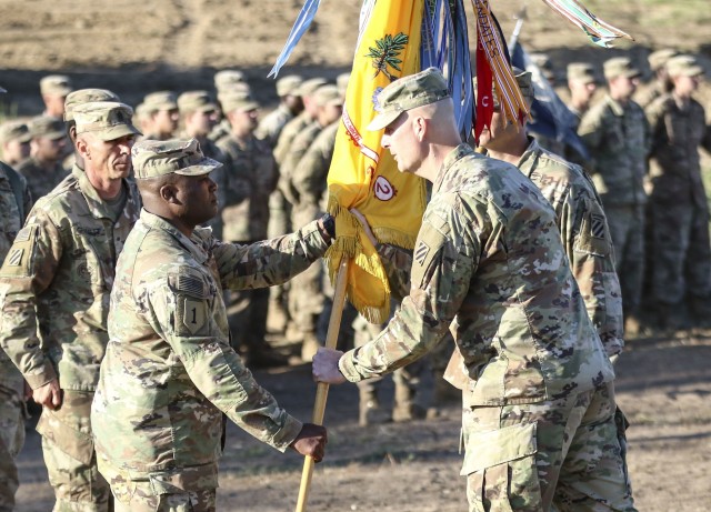 Col. Patrick S. O'Neal, commander of 2nd Armored Brigade Combat Team, 3rd Infantry Division, passes the 2nd Battalion, 69th Armored Regiment colors to Lt. Col. George Bolton, signifying the transfer of command during the battalion's change of...