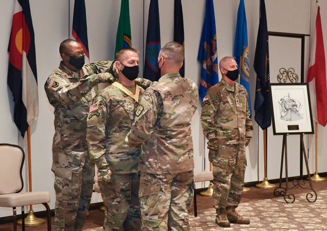 Command Sgt. Maj. Gennaro Penn, left, and Col. Stephen Aiton, Soldier Support Institute commander, place a medal around the neck of Col. Greg R. Worley after he became the 41st commandant of the Financial Management and Comptroller School and...