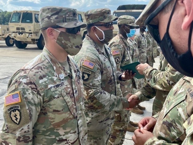 Lt. Col. Jeffery Fuller and Command Sgt. Maj. Antonio Morris, commander and senior enlisted leader of 1-41 FA, 1ABCT, 3rd ID, award the Expert Gunner badge to Staff Sgts. Johnpaul Taylor and Willy Zapata Aug. 7 on Fort Stewart. (U.S. Army photo by...