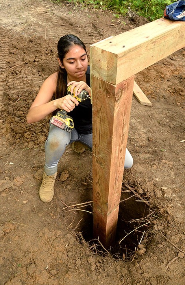 Junior ROTC Cadet Sgt. Kiyomi Rico, Leavenworth High School junior, drills a brace in place on an over-under obstacle Aug. 8 at the obstacle course behind the school. Photo by Prudence Siebert/Fort Leavenworth Lamp
