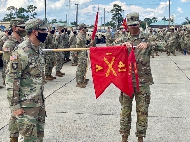 Lt. Col. Jeffery Fuller, commander of 1-41 FA, 1ABCT, 3rd ID, places the Top Gun and Top Fire Direction Center streamers on Alpha battery’s guidon Aug. 7 on Fort Stewart. Soldiers assigned to 1-41 competed for the Top Gun and Top Field Direction...