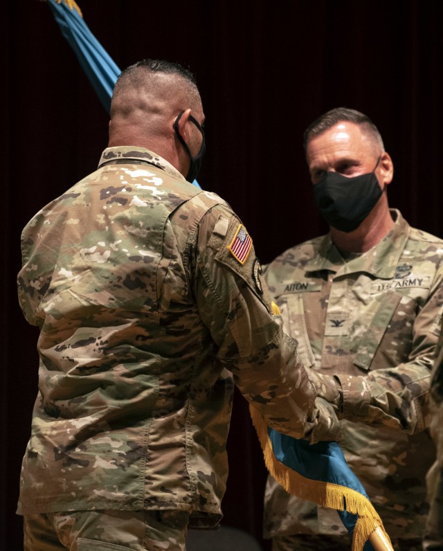 Col. Stephen Aiton, Soldier Support Insitute commander, takes the unit colors from Command Sgt. Maj. Jorge Escobedo, during a change of responsibility ceremony July 31 in the SSI Auditorium. Escobedo relinquished responsibilty to Command Sgt. Maj....