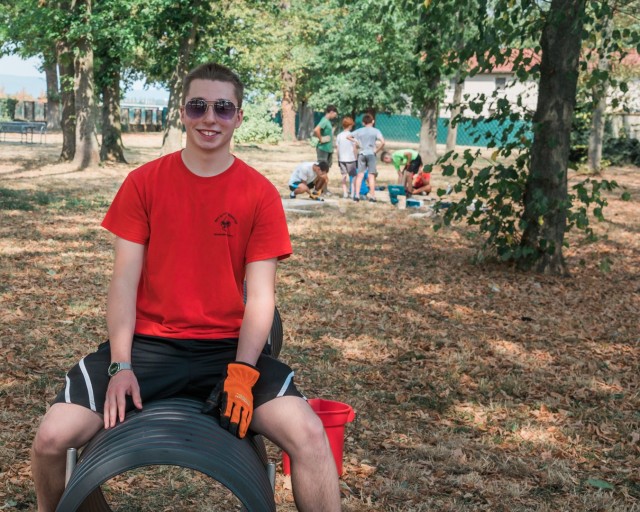 WIESBADEN, Germany - Tyler Houk sits on a section of the dog tunnel while volunteer scouts build the ramp component of the project at the dog park on Clay Kaserne August 12, 2020.