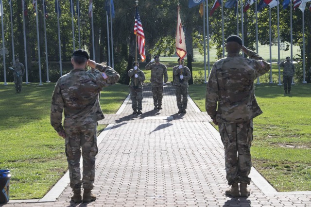 Col. John 'Wes' Hankins, garrison commander, and Garrison Command Sgt. Maj. Anthony Wilson salute the U.S. flag during a change of responsibility ceremony July 31 at Victory Field. In the ceremony, Wilson relinquished responsibilty of the unit.