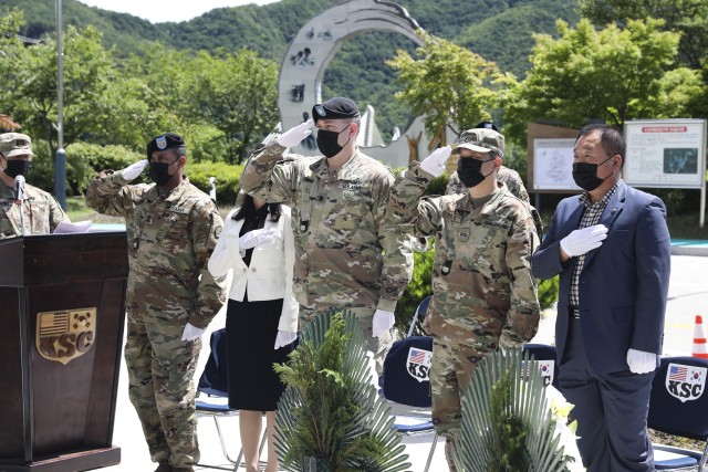 Sgt. Maj. David J. Caleb, Korean Service Corps. bn. senior enlisted advisor, Mrs. Jenny Kim Cooper, Spouse of the bn. commander, Lt. Col. John E. Cooper, KSC bn. commander, Mr. Yi, Chin U, KSC bn. deputy commander, and Mr. Yo, In Chon, KSC union president salute the flags of the United States and the Republic of Korea during the playing of each countries national anthum at the KSC Korean War Memorial during a 70th Anniversary commemoration ceremony in Inje, South Korean, July 26, 2020. (U.S. Photo by Staff Sgt. Jacob Kohrs)