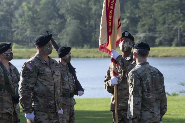 Garrison Command Sgt. Maj. Anthony Wilson inspects the garrison colors before passing them  to Col. John 'Wes' Hankins, garrison commander during a relinquishment of responsibility ceremony July 31 at Victory Field.