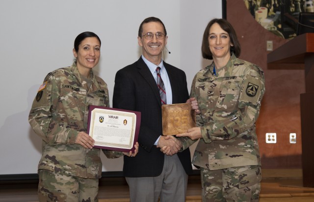 Col. Deydre Teyhen and Command Sgt. Maj. Natasha Santiago recognize and thank Dr. John Mascola, National Institute of Allergy and Infectious Disease, at WRAIR’s 2019 event marking World AIDS Day on November 26, 2019