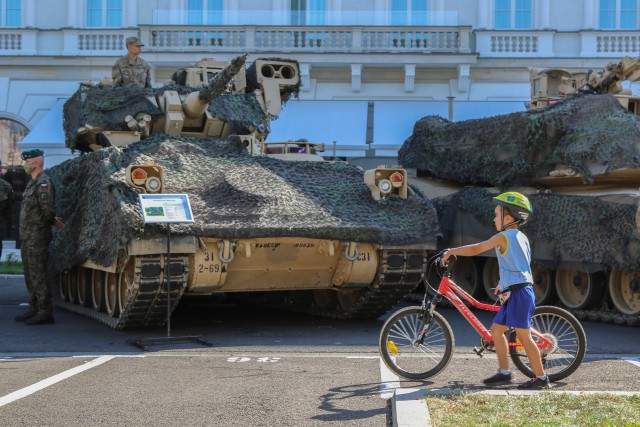 A boy pushes his bicycle in front of tanks, which are part of a static display, during events commemorating the 100th anniversary of the Battle of Warsaw and Armed Forces Day in Warsaw, Poland, Aug. 15, 2020. U.S. participation in the ceremony was to honor Poland’s past, as well as show commitment to the future with Poland as allies. (U.S. Army photo by Cpl. Justin W. Stafford)
