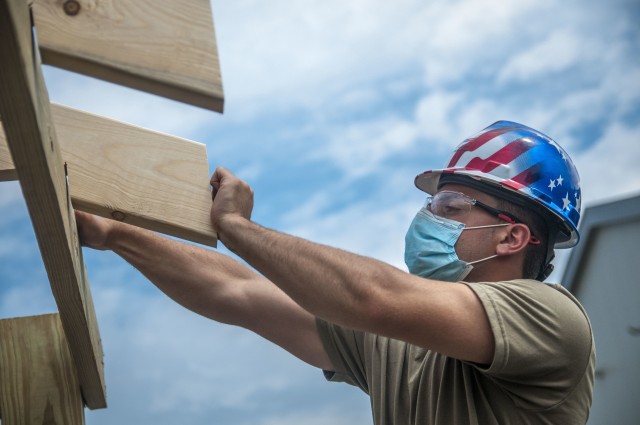 TAUNTON, Mass. – A soldiers assigned to the 338th Engineer Company helps construct a gazebo at the Army Reserve Center, here, Aug. 13, 2020. This construction project will help provide a shaded area for Soldiers to take breaks while working in the motor pool.