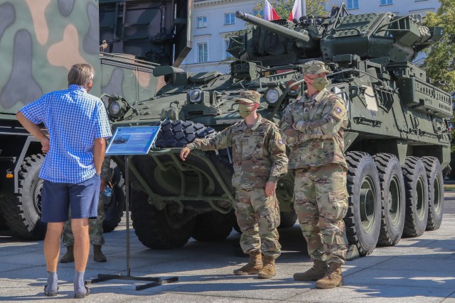 A U.S. Army Soldier assigned to enhanced Forward Presence Battle Group Poland speaks to an attendee at a static display during events commemorating the 100th anniversary of the Battle of Warsaw and Armed Forces Day in Warsaw, Poland, Aug. 15, 2020. U.S. participation in the ceremony was to honor Poland’s past, as well as show commitment to the future with Poland as allies. (U.S. Army photo by Cpl. Justin W. Stafford)
