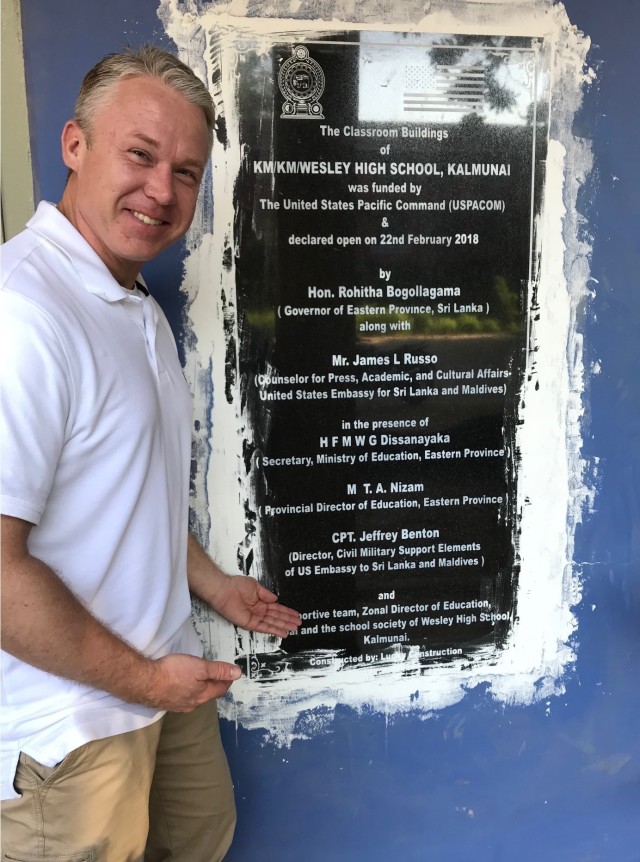 Capt. Jeff Benton, civil affairs officer, 1st Theater Sustainment Command, stands in front of a school plaque in Sri Lanka, with dedications to all the personnel involved in its renovation. Benton, along with his team of civil affairs Soldiers, worked with the government and local authorities to restructure buildings in the city of Batticaloa in 2018. (Courtesy Photo)