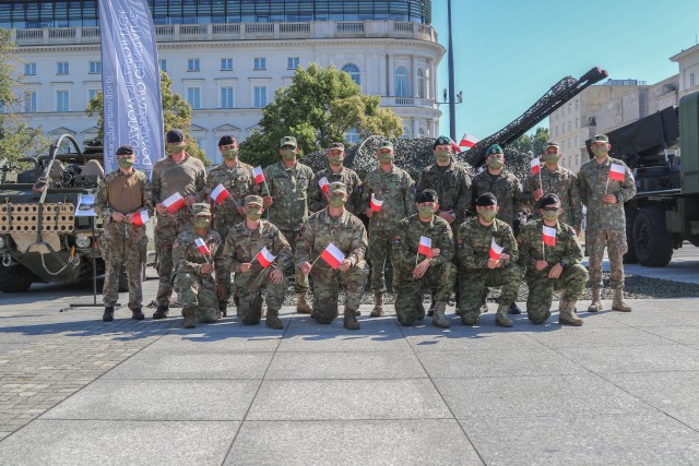 Croatian, Romanian, U.K., and U.S. Soldiers assigned to NATO enhanced Forward Presence Battle Group Poland pose for a photo with Polish flags in front of equipment displays during events commemorating the 100th anniversary of the Battle of Warsaw and Armed Forces Day in Warsaw, Poland, Aug. 15, 2020. The U.S. continues to work with its Polish and NATO eFP partners to maintain security and stability in the region. (U.S. Army photo by Cpl. Justin W. Stafford)
