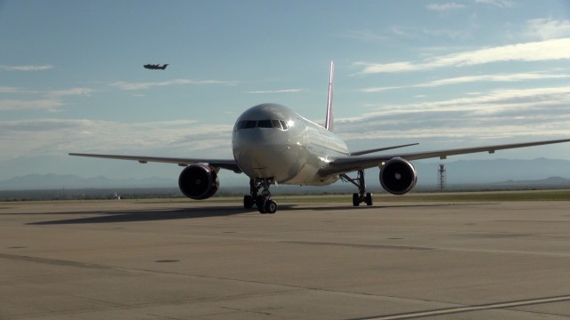 A passenger jet taxis at Libby Army Airfield enroute to dropping off redeploying Soldiers while a training flight takes off from the Fort Huachuca, Ariz. facility.