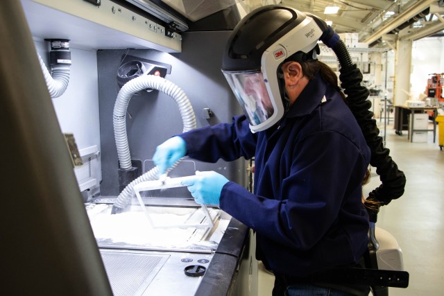 Barrett Craps, additive manufacturing specialist, Rock Island Arsenal - Joint Manufacturing and Technology Center, Advanced and Additive Manufacturing Center of Excellence, brushes powder off completed ventilator housing parts, April 9, 2020 at...