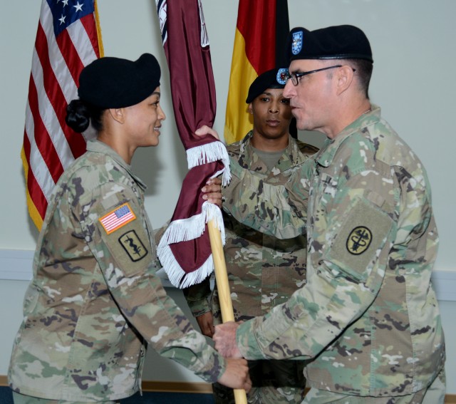 Col. Stephen Tanner, Dental Health Command Europe Commander, passes the unit colors to Master Sgt. (P) Tres Bien Adams during an Assumption of Responsibility Ceremony, Sept. 28, 2018 at Sembach, Germany (U.S. Army photo by Visual Information Specialist Elisabeth Paque)