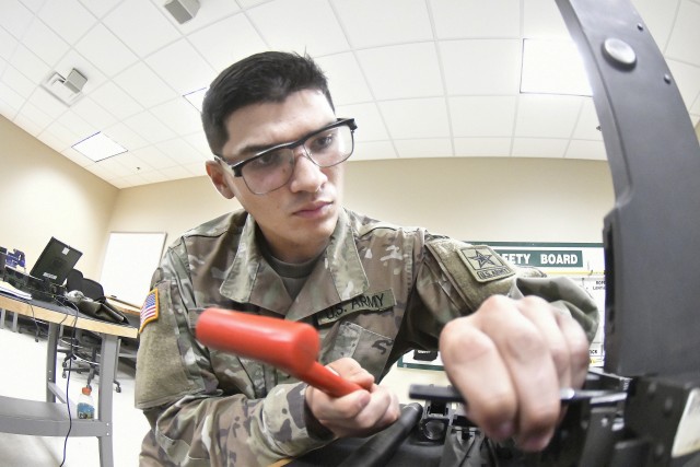 Pvt. Stephan Plass, Bravo Company, 832nd Ordnance Battalion, uses a small mallet to force a screw into place during 94T Short Range Air Defense System Repairer Course training Aug. 12.