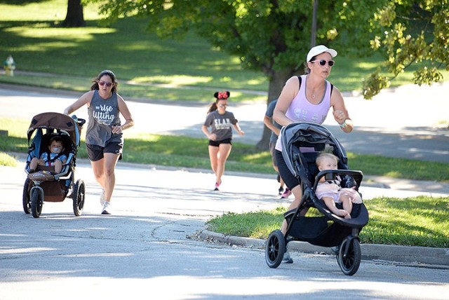 Stroller Strong Moms/Sweat Like a Mother class participants Katie Pinheiro, with 16-month-old Decker, and Tasha Nunes, with 9-month-old Emelia, complete a lap around the Post Theater during the SLAM class Aug. 18 in the Merritt Lake parking lot. The fitness class is offered at 8:45 a.m. throughout the week with distancing and limited class size. Multiple instructors are available, so once a class fills, another is added if needed. Registration is required; see the group's Facebook page to sign up. Photo by Prudence Siebert/Fort Leavenworth Lamp