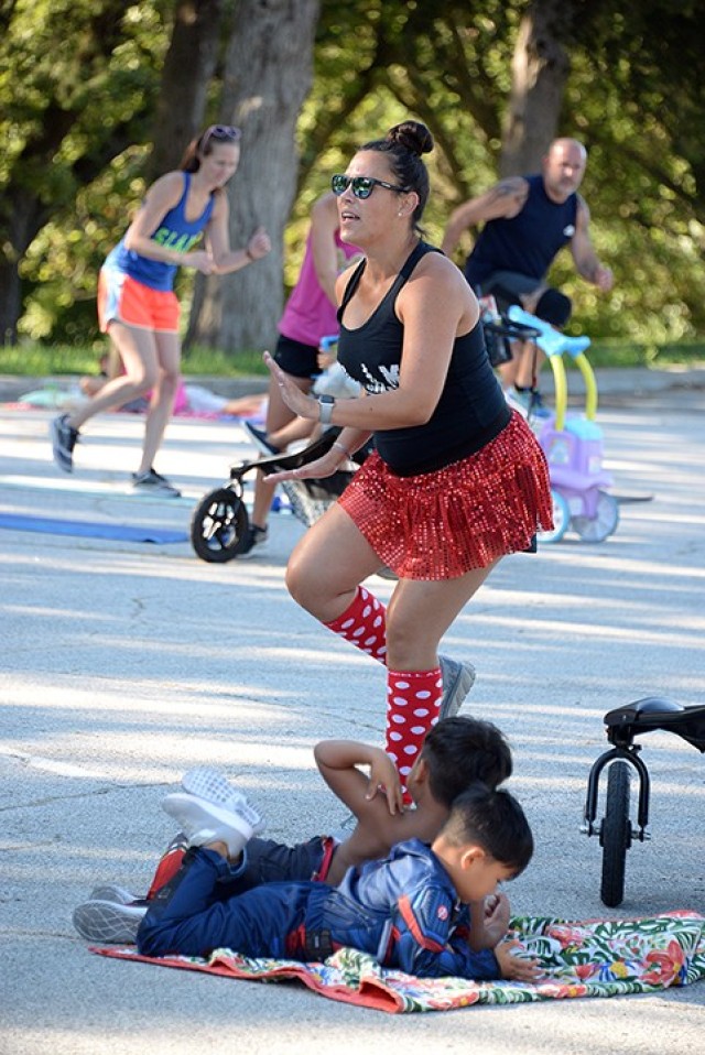 Stroller Strong Moms/Sweat Like a Mother coach Sarah Wong, accompanied by her sons 3-year-old Sebastian and 5-year-old Killian, leads the Disney-themed class celebrating four years of SLAM-Leavenworth Aug. 18 in the Merritt Lake parking lot. Class participants wore Disney-related clothing or costumes for their morning workout and shared their favorite Disney movie when they introduced themselves. The fitness class is offered at 8:45 a.m. throughout the week with distancing and limited class size. Multiple instructors are available, so once a class fills, another is added if needed. Registration is required; see the group's Facebook page to sign up. Photo by Prudence Siebert/Fort Leavenworth Lamp