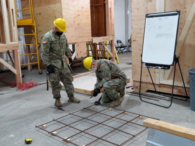 Sgt. Nathan Johnson, 649th Regional Support Group, Cedar Rapids, Iowa; and Spc. Jordan Barnett, 947th Engineer Company, Montrose, Colorado, learning how to construct a rebar flat. Johnson is a 15H Aircraft Pneudraulics Repairer reclassifying as a...