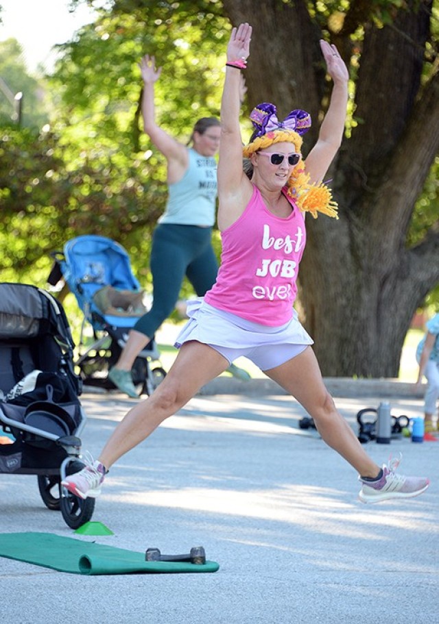 Instructor Wanda Aviles leaps in the air while helping lead exercises in the Disney-themed Stroller Strong Moms/Sweat Like a Mother class celebrating four years of SLAM-Leavenworth Aug. 18 in the Merritt Lake parking lot. Class participants wore Disney-related clothing or costumes for their morning workout and shared their favorite Disney movie when they introduced themselves. The fitness class is offered at 8:45 a.m. throughout the week with distancing and limited class size. Multiple instructors are available, so once a class fills, another is added if needed. Registration is required; see the group's Facebook page to sign up. Photo by Prudence Siebert/Fort Leavenworth Lamp