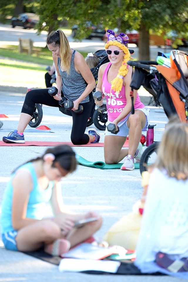 As kids in strollers and on blankets occupy themselves with devices and books, Allison Beeman and Wanda Aviles perform exercises in the Disney-themed Stroller Strong Moms/Sweat Like a Mother class celebrating four years of SLAM-Leavenworth Aug. 18 in the Merritt Lake parking lot. Class participants wore Disney-related clothing or costumes for their morning workout and shared their favorite Disney movie when they introduced themselves. The fitness class is offered at 8:45 a.m. throughout the week with distancing and limited class size. Multiple instructors are available, so once a class fills, another is added if needed. Registration is required; see the group's Facebook page to sign up. Photo by Prudence Siebert/Fort Leavenworth Lamp