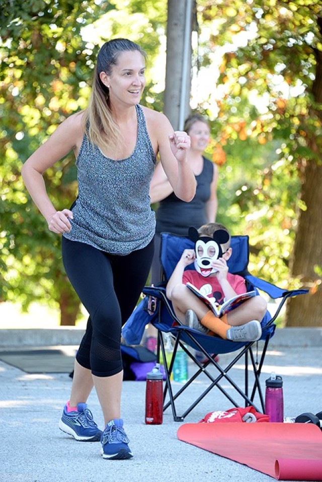 Allison Beeman exercises while her son, 6-year-old Caleb, adjusts his Mickey Mouse mask to continue coloring during the Disney-themed Stroller Strong Moms/Sweat Like a Mother class celebrating four years of SLAM-Leavenworth Aug. 18 in the Merritt...