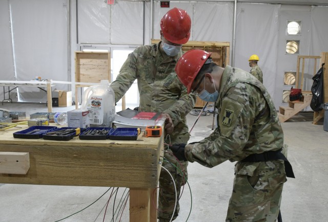 Sgt. Zachary Squires with the 486th Engineer Co. based in Monclova, Ohio; and Spc. Edgar Torres with the 333rd Engineer Detachment based in Sante Fe, New Mexico putting newly acquired wiring skills to work during the inaugural 12R10 Interior...