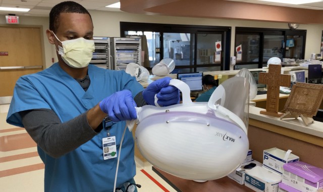 U.S. Air Force Staff Sgt. Jarrid Wilson, cardiopulmonary lab technician, COVID Theater Hospital-1, cleans his personal protective equipment after assisting a patient at Adventist Health in Hanford, Calif., Aug. 4, 2020. U.S. Northern Command,...