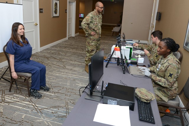 Spc. Shunterika Fields and Army Pvt. Stephen Hines create ID cards to track non-patient personnel’s temperatures at the temporary medical facility in New Orleans, April 4. U.S. Northern Command, through U.S. Army North, is providing military support to the Federal Emergency Management Agency to help communities in need.