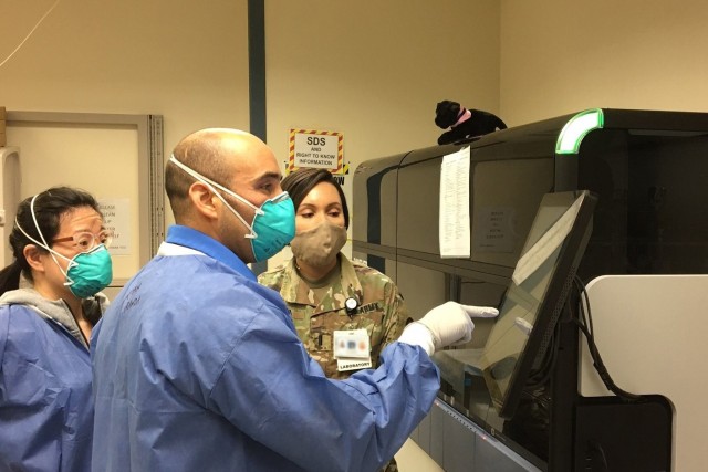 Dr. Roman Aranda, Supervisory Chemist, and Dr. Bo Liu, Chemist, process samples on the Panther Fusion at the Dwight D. Eisenhower Army Medical Center at Ft. Gordon, Ga.