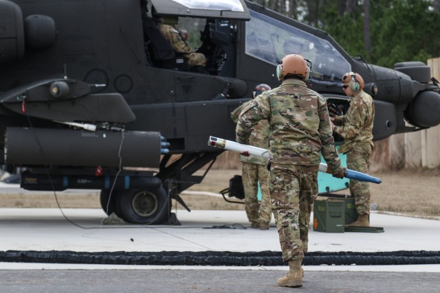 Soldiers assigned to 1st Attack Reconnaissance Battalion, 82nd Combat Aviation Brigade, prepare ammunition and fuel for a U.S. Army AH-64D Apache Longbow during an aerial gunnery range exercise at Fort Bragg, North Carolina, Jan. 27, 2020.  The FARP acts as a refueling and ammunition point for the range operations. (U.S. Army photo by Pfc. Joshua Cowden, 22nd Mobile Public Affairs Detachment)
